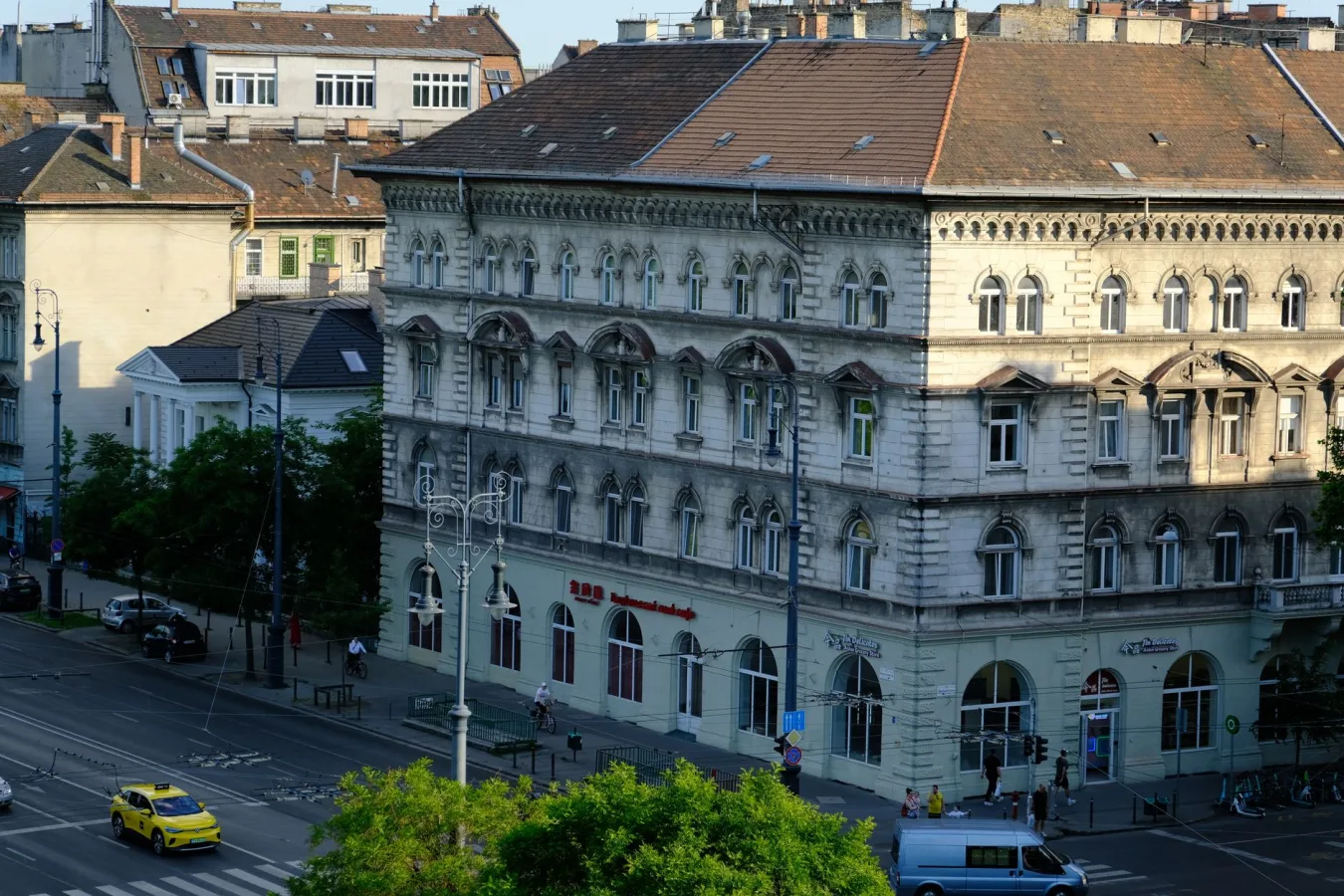 Aerial view of a historic European building with city street and vehicles below.