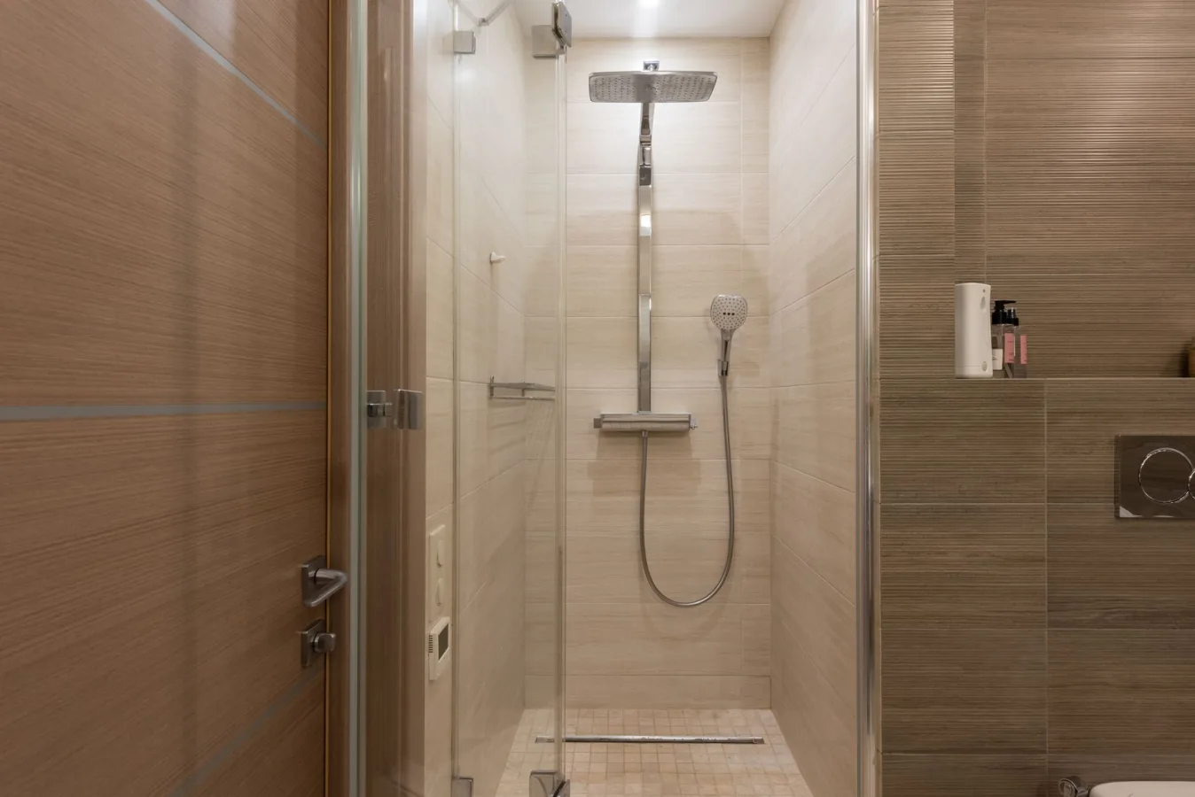 Sleek modern shower with glass door in a contemporary bathroom setting, featuring elegant