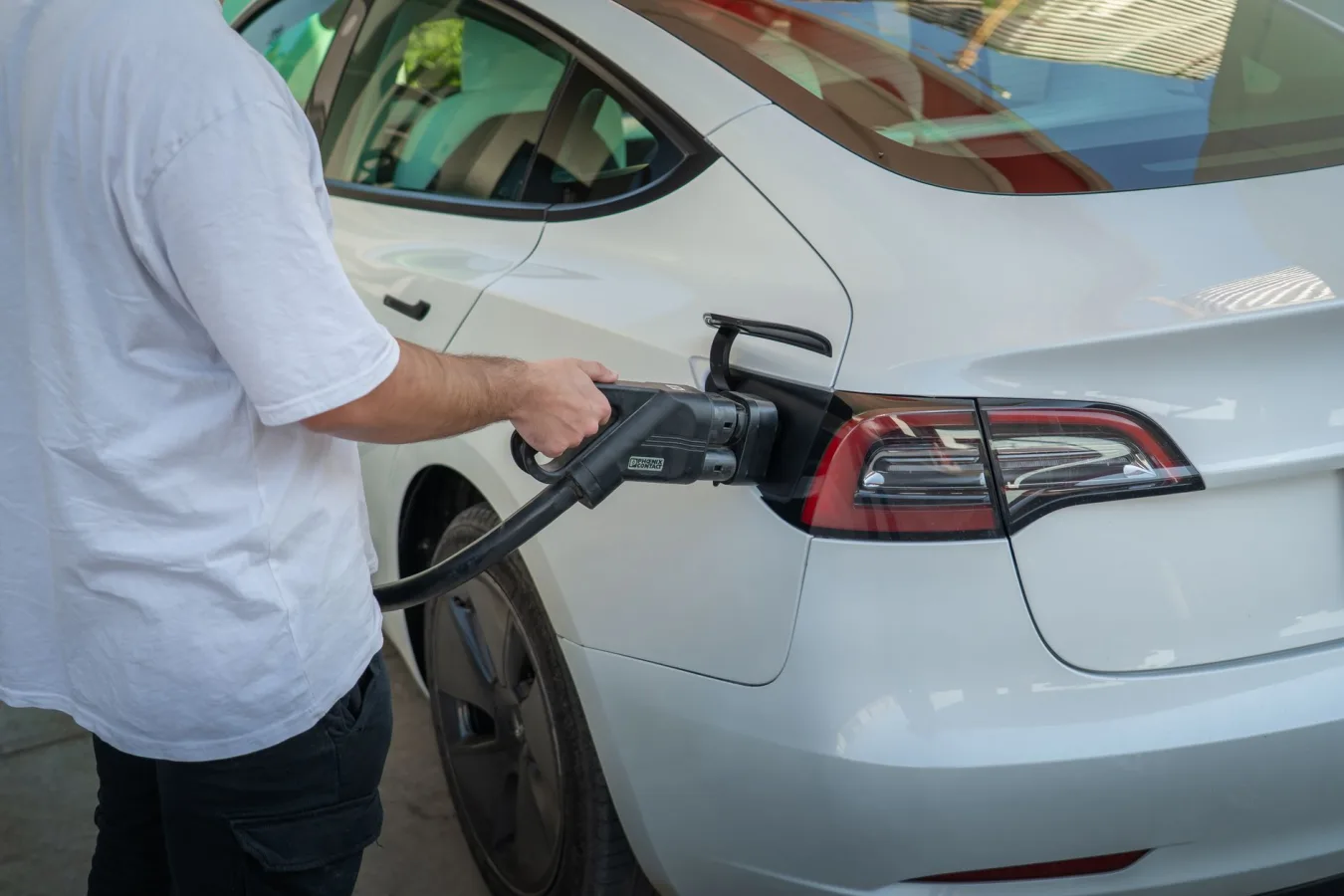 Electric car being charged at a station, highlighting eco-friendly transportation.