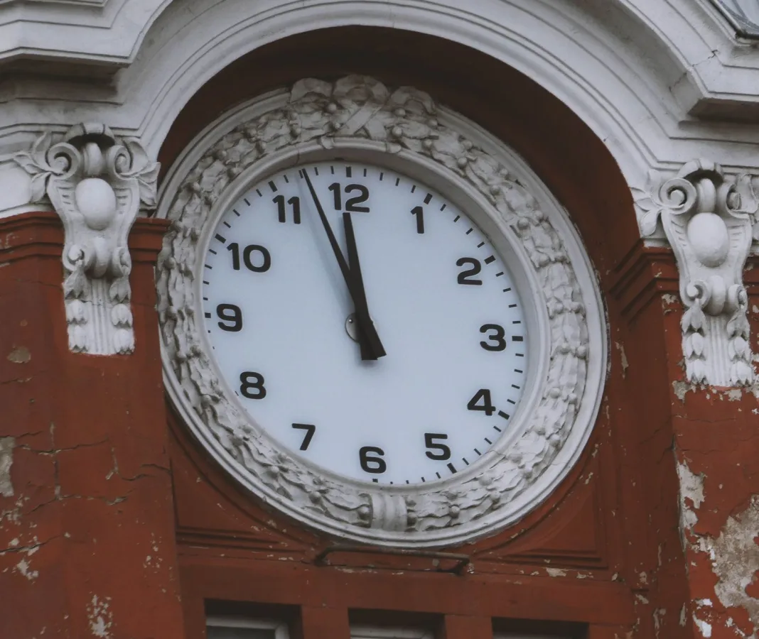 Close-up of an ornate clock tower showing midnight or noon, capturing timeless architectur