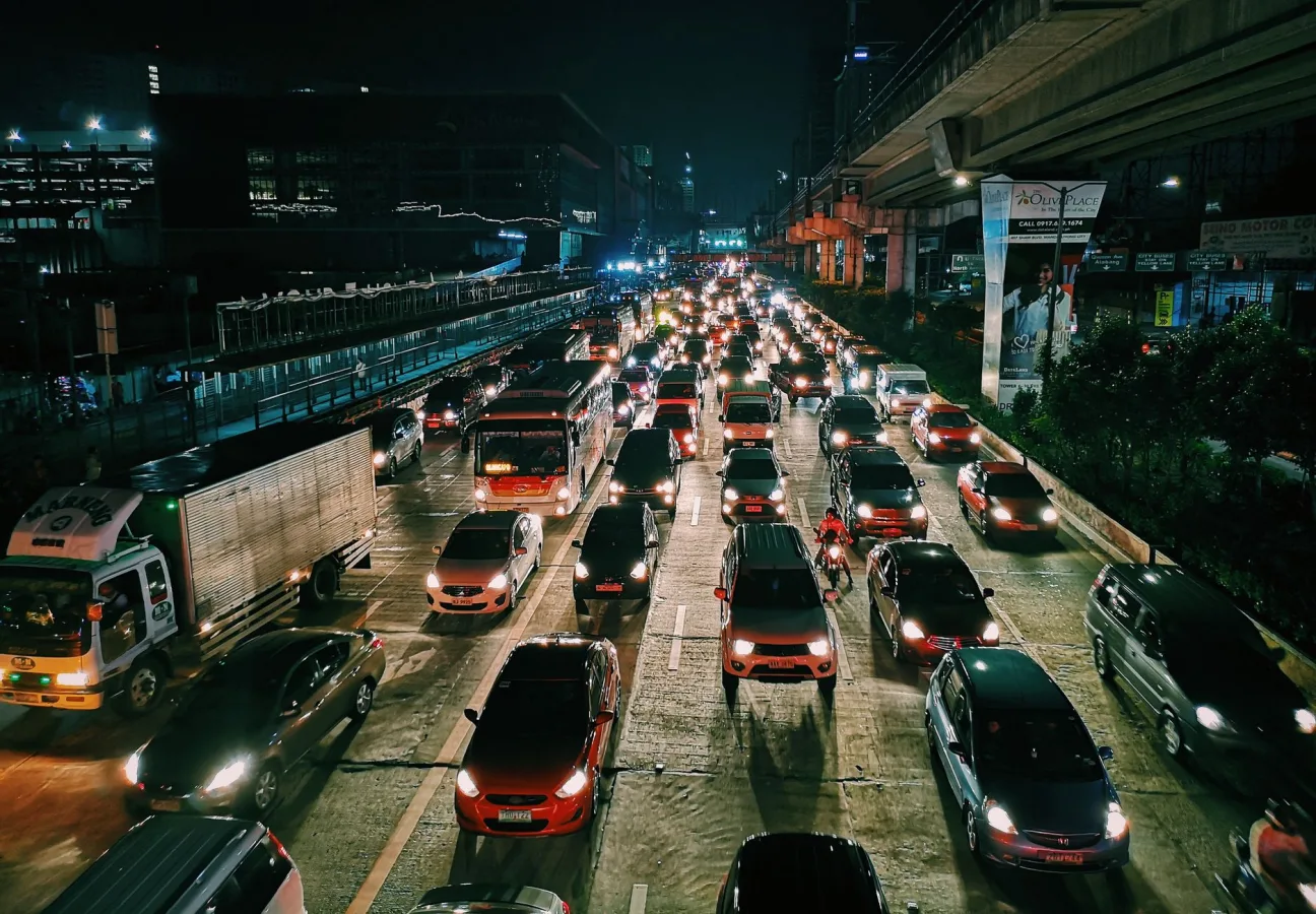 A bustling urban highway filled with cars and buses at night, showcasing city life and tra
