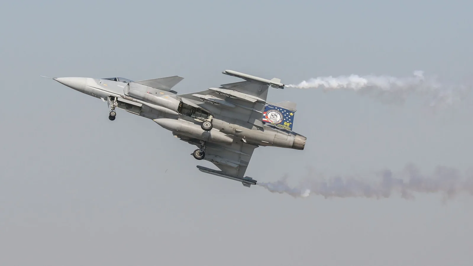 A sleek fighter jet showcasing impressive aerial maneuvers during a daytime air show.