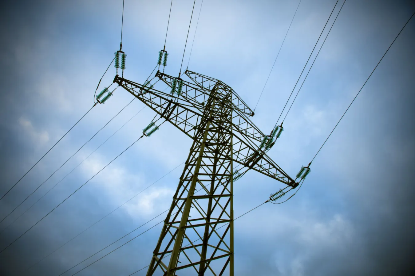 A majestic transmission tower stands tall against a cloudy blue sky, showcasing modern ele
