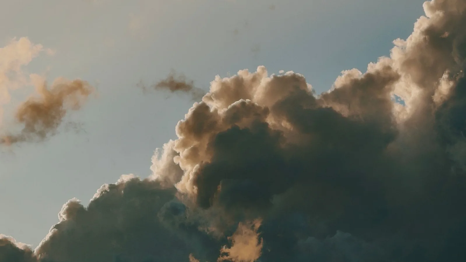 A dramatic cloudscape with sunlit clouds during day time, creating a moody atmosphere.